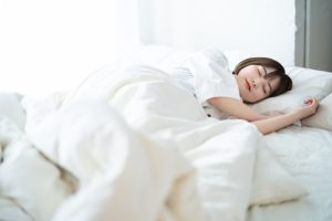 ベッドで眠る女性の写真